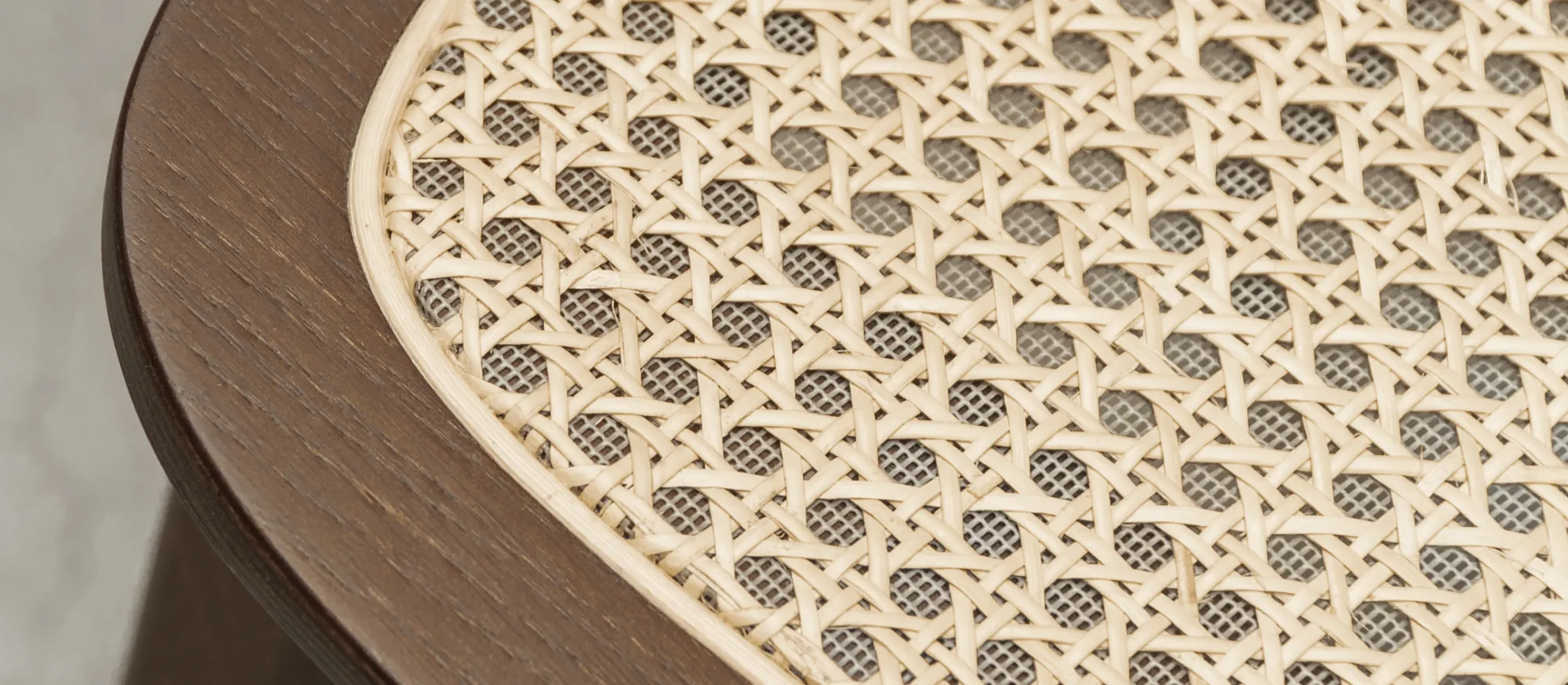 Close-up of Titus dining chair by Vincent Sheppard, with oak frame and finely handwoven natural cane seat.