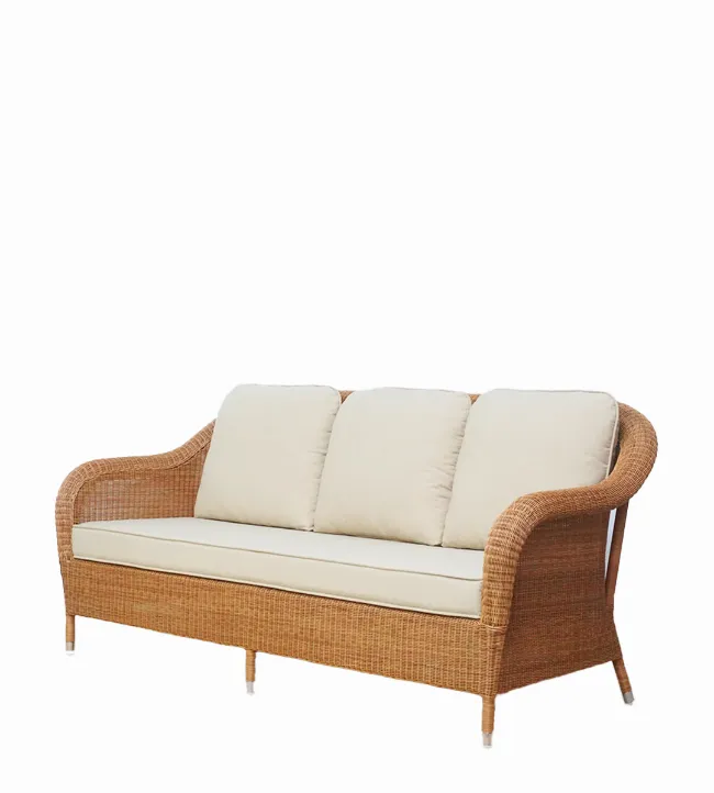Angled view of the Riviera 3-seater sofa in honey synthetic wicker with beige cushions by Vincent Sheppard.