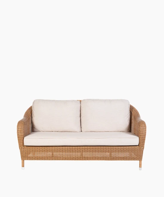 Riviera 2.5-seater sofa by Vincent Sheppard, featuring a Honey-colored synthetic rattan weave with light beige cushions and gently curved armrests.