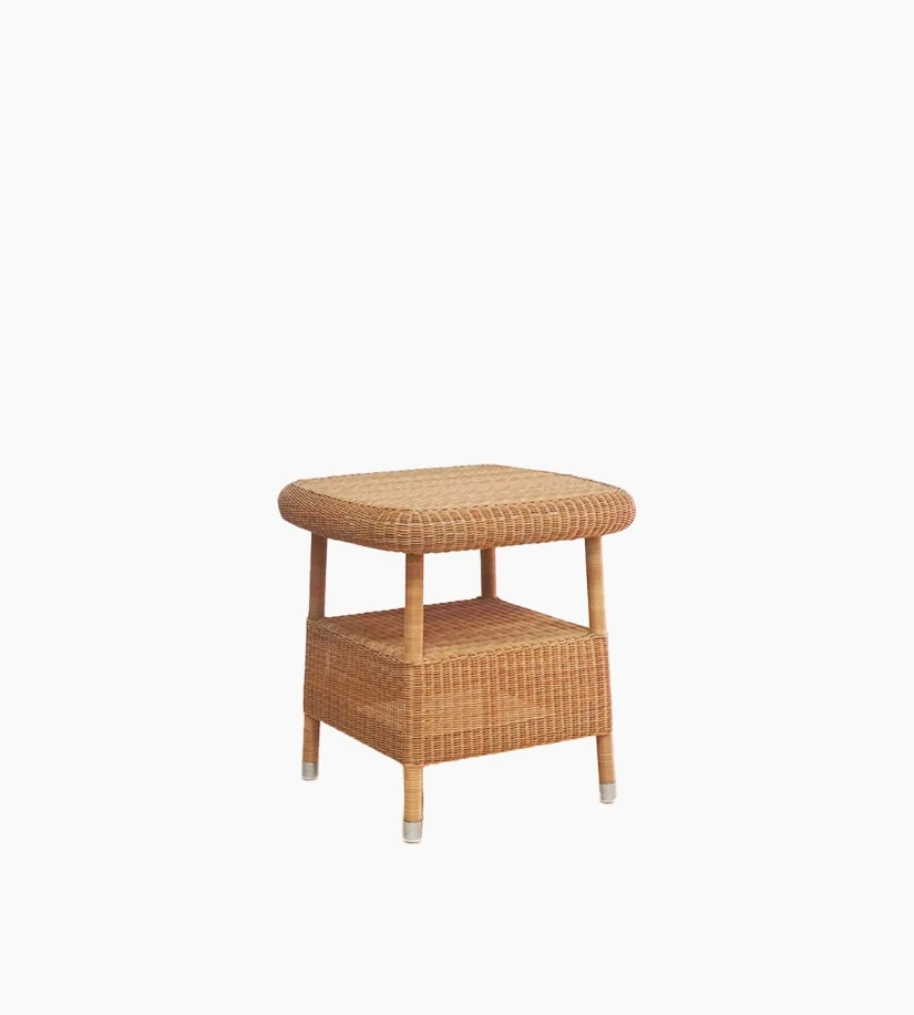 Vincent Sheppard’s Riviera side table in honey synthetic wicker with a lower shelf and rounded edges.