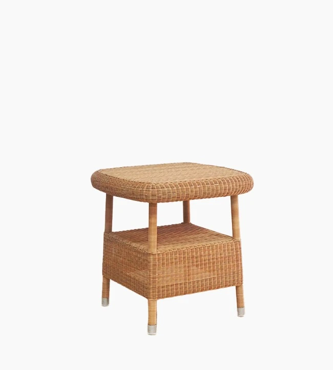 Vincent Sheppard’s Riviera side table in honey synthetic wicker with a lower shelf and rounded edges.