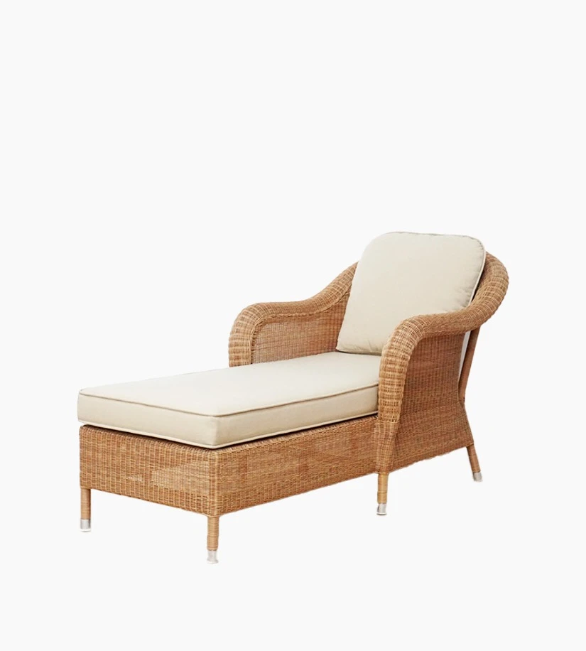 Side view of the Riviera daybed in honey synthetic wicker with beige cushions by Vincent Sheppard.