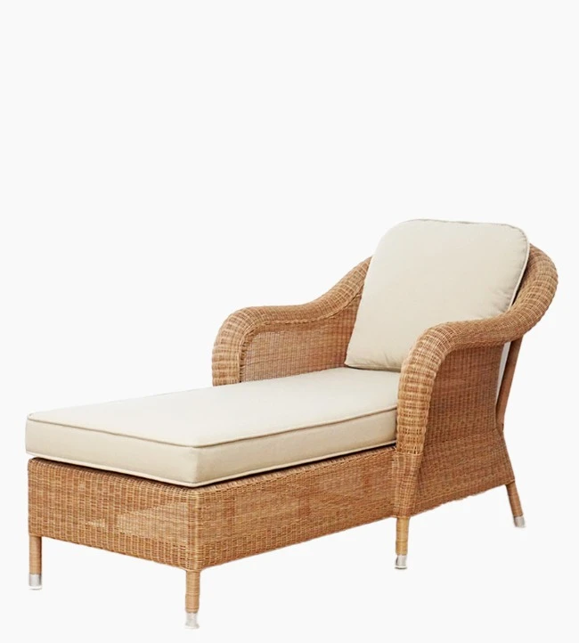 Side view of the Riviera daybed in honey synthetic wicker with beige cushions by Vincent Sheppard.